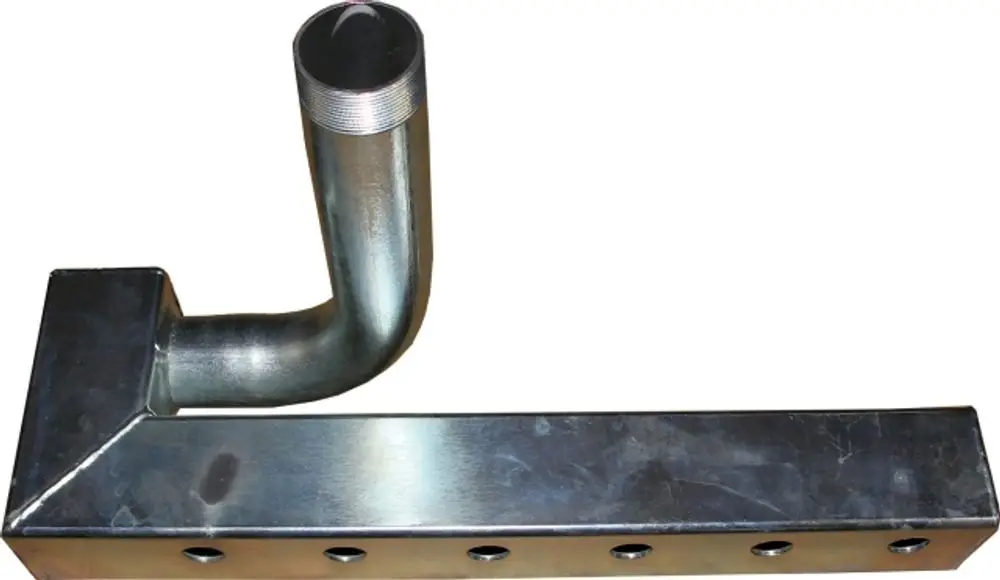 Vorlauf-Gussblock von Wolf mit einer L-Form und einem gebogenen Auslass, auf einer Metalloberfläche, sichtbar sind mehrere Löcher zur Befestigung.